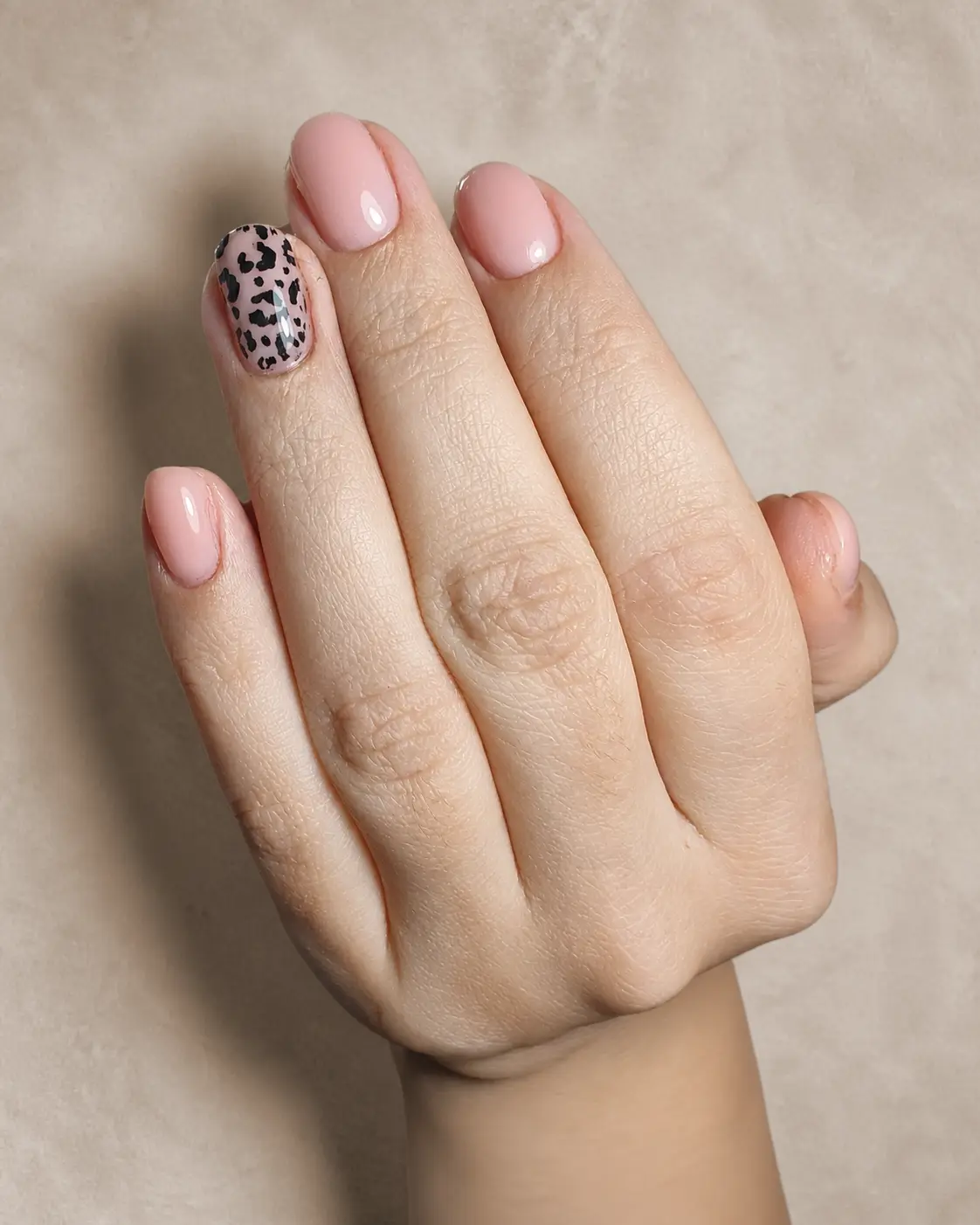 Zwei Hände mit Nägeln in Nude, je ein Nagel mit Leopardenmuster.